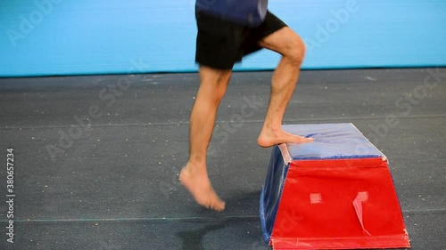 a still shot of a guy in a gymnastics gym doing 
from a photo