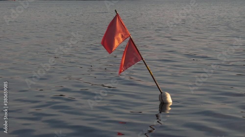 Sea beacon with red flag photo