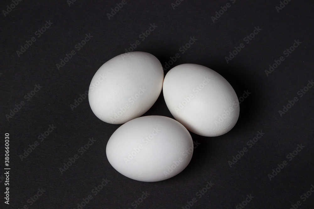 Eggs on a black background. White chicken eggs Eggs on a black background. White chicken eggs