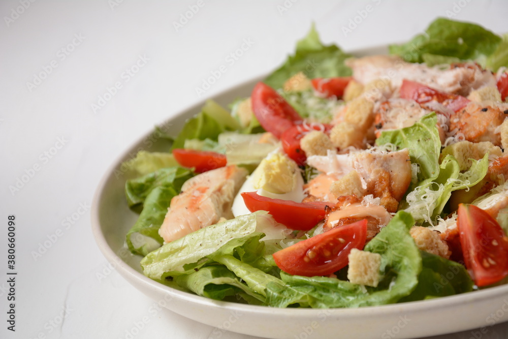 Caesar Salad with grilled chicken, Cheese and Croutons with lettuce, on plate. Grilled chicken breasts and fresh vegetables in plate. Caesar Salad with grilled chicken, Cheese and Croutons with lettuce, on plate. Grilled chicken breasts and fresh vegetables in plate.