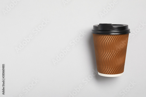 Takeaway paper coffee cup on light grey background, top view. Space for text