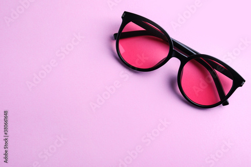Stylish sunglasses on light violet background, top view. Space for text