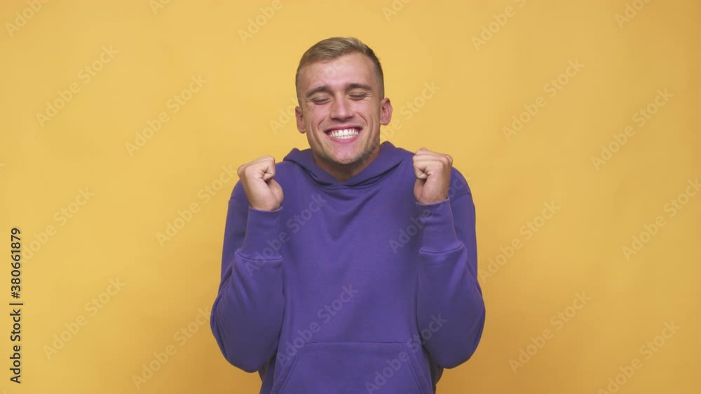 Young caucasian man raising fist, feeling happy and successful victory concept Young caucasian man raising fist, feeling happy and successful victory concept