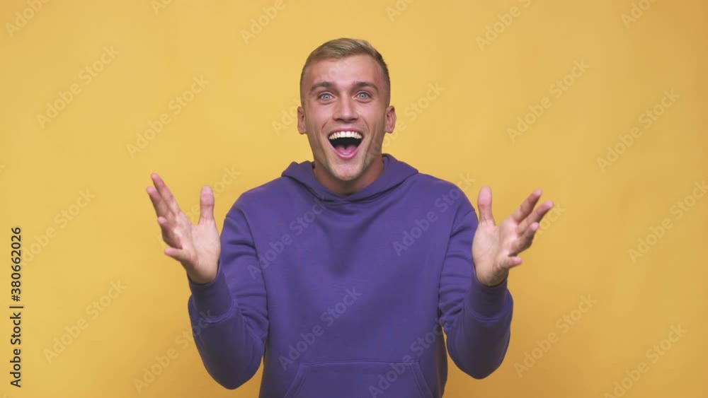 Young caucasian man receiving a pleasant surprise, excited and raising hands Young caucasian man receiving a pleasant surprise, excited and raising hands