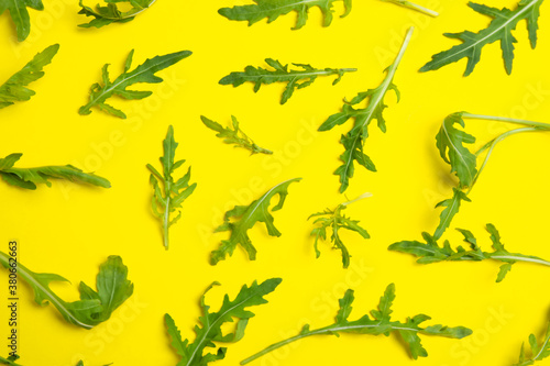 Fresh arugula on yellow background  flat lay