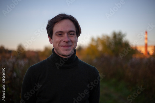 Portrait of a guy in the sunlight. Young man in nature. A student is skipping school in the woods. A guy with a regular haircut. A young man of European appearance. A man on a summer day.