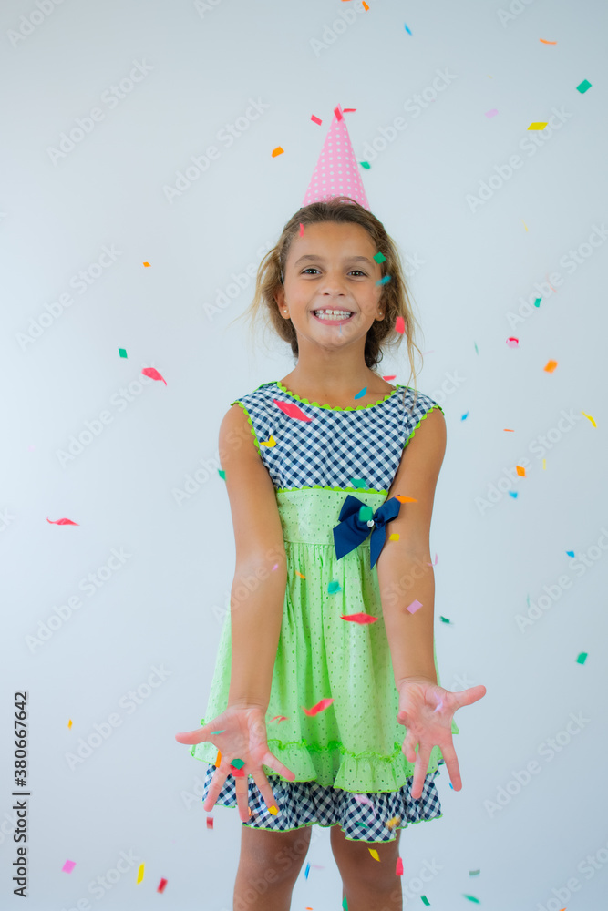 Cute adorable little small girl celebrating birthday standing isolated over white background