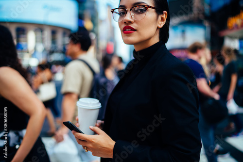 Young woman with cellphone and coffee in downtown