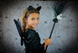 funny child girl in witch costume for Halloween over cobweb background