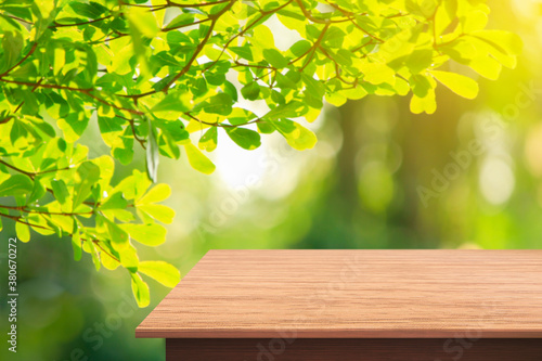 Empty wooden deck table with garden bokeh background. for product display montage.