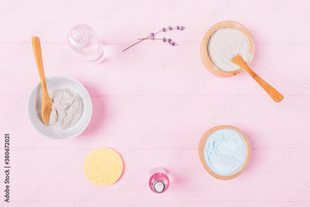 Flat lay cosmetic clay face mask with lavender aroma oil and water on pink background Flat lay cosmetic clay face mask with lavender aroma oil and water on pink background