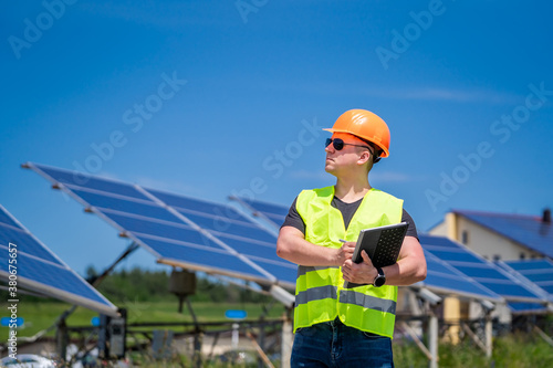 Engineer is looking out at new energy base of solar system panels. Green energy.