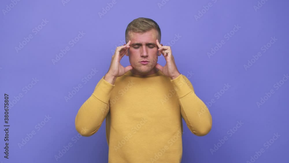 Young caucasian man touching temples and having headache Young caucasian man touching temples and having headache