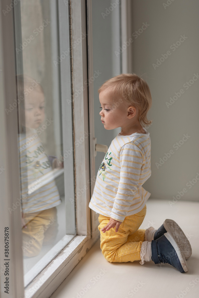 little girl sits on the windowsill and looks out the window
little girl sits on the windowsill and looks out the window
