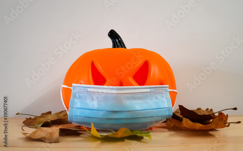 Halloween pumpkin with a protective medical mask on a white background. Halloween symbol 2020