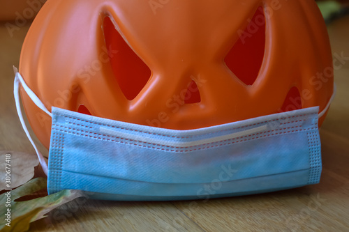 Halloween pumpkin with a protective medical mask on a white background. Halloween symbol 2020