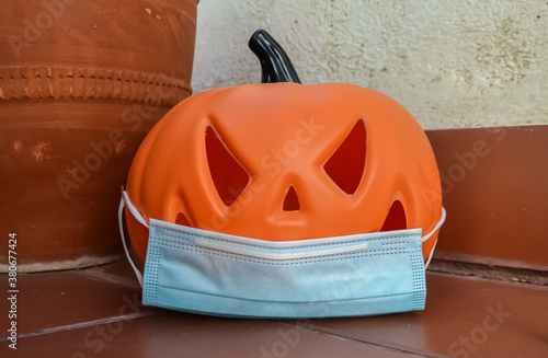 Halloween pumpkin with a protective medical mask on a white background. Halloween symbol 2020
