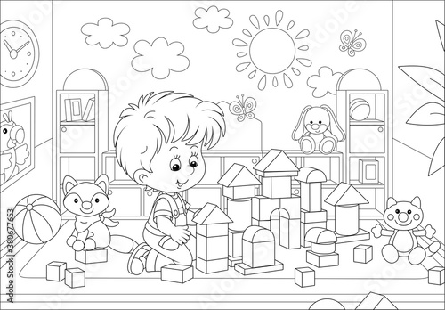 Happy little boy playing with bricks and constructing a funny toy fortress for game in a playroom of a kindergarten, black and white vector cartoon illustration for a coloring book page