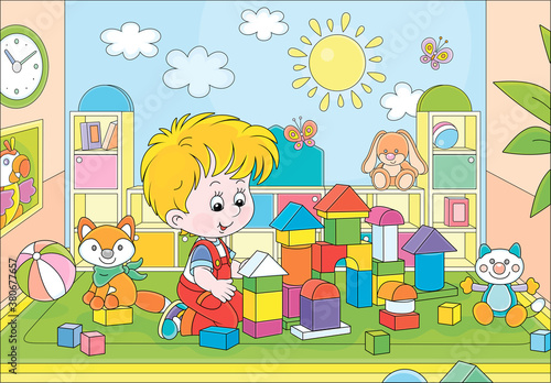 Happy little boy playing with color bricks and constructing a funny toy fortress for game in a playroom of a kindergarten, vector cartoon illustration