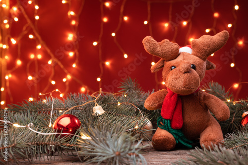 Portrait of a cute reindeer toy in santa hat sitting in a Christmas