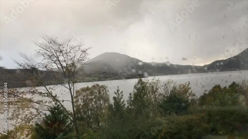 Rainy motion timelapse in Norwegian fjords and moutains. Filmed inside through wet window on motorised slider. photo