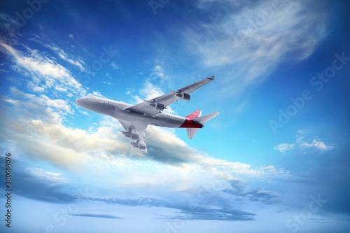 Airplane flying in blue sky with clouds. Air transportation