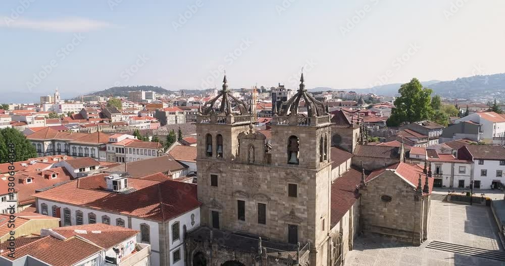 Old And Historic Building Of Braga Cathedral (Se De Braga) With A Scenic View Of The Typical Houses At Braga City, Portugal In Summer. - aerial arc shot - ascending Old And Historic Building Of Braga Cathedral (Se De Braga) With A Scenic View Of The Typical Houses At Braga City, Portugal In Summer. - aerial arc shot - ascending