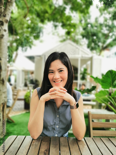 An Asian woman feeling happy and smiling in the garden