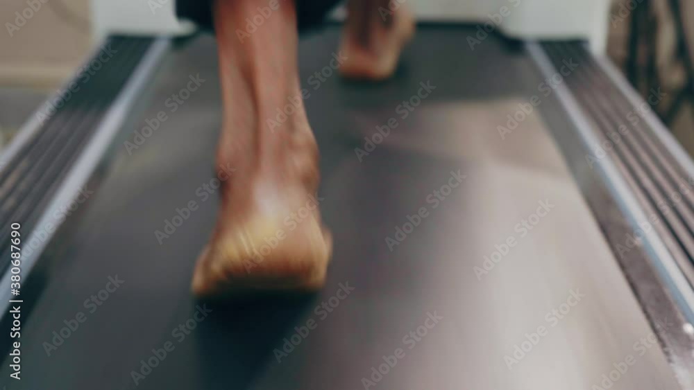 Closeup shot of a man walking in hospital treadmill during ECG testing of heart rate Closeup shot of a man walking in hospital treadmill during ECG testing of heart rate