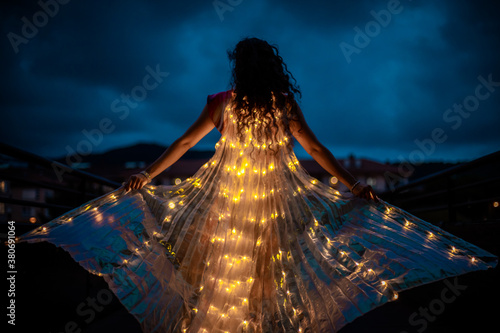 Belly dancer with light wings at night