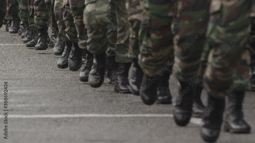 Many men marching in boots and army clothing Many men marching in boots and army clothing
