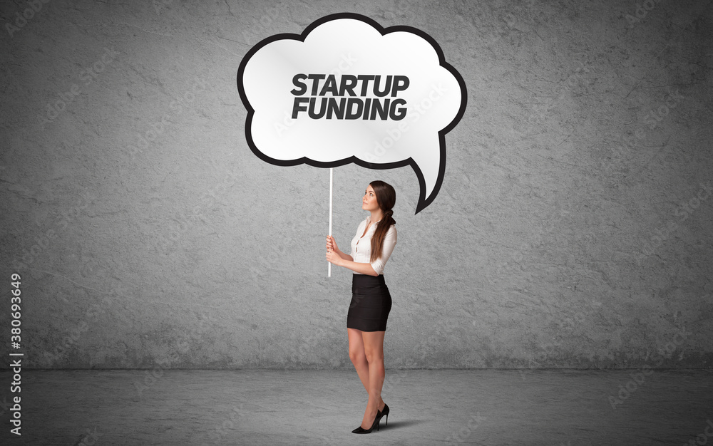 Young business person in casual holding road sign with STARTUP FUNDING inscription, new business idea concept Young business person in casual holding road sign with STARTUP FUNDING inscription, new business idea concept
