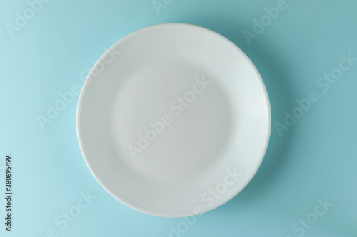 White empty plate on blue background.