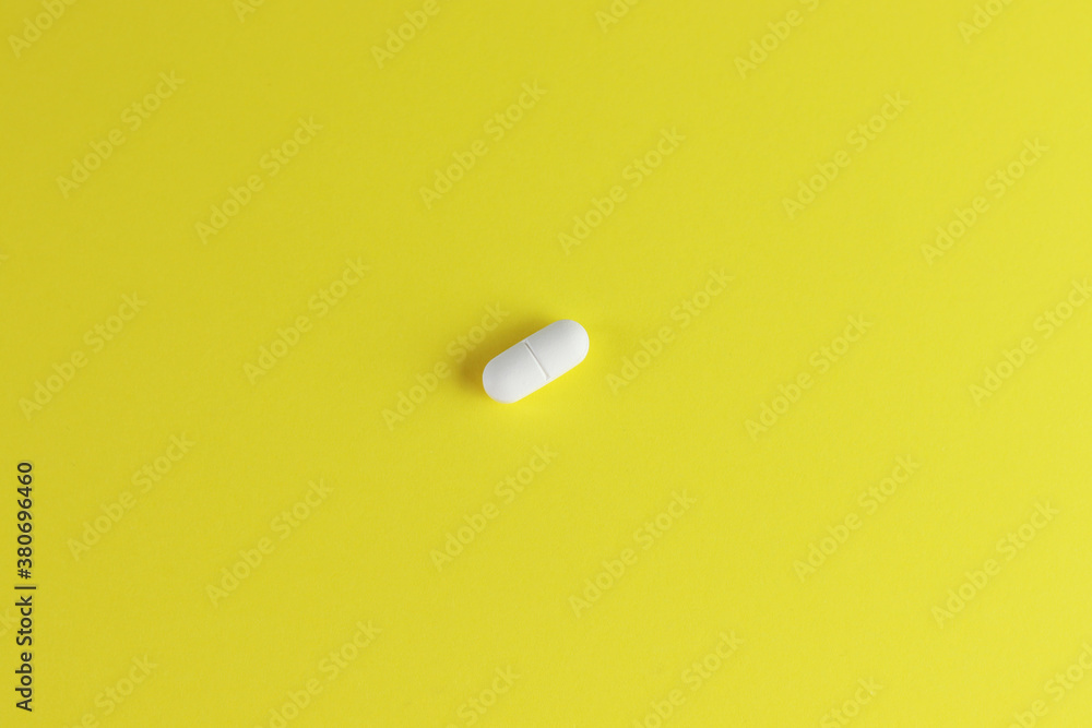 White pill isolated on yellow background with place for text White pill isolated on yellow background with place for text