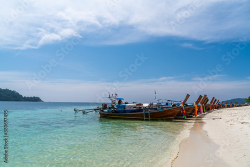 Traditional long tail boats in crystal clear water in Sai Khao Beach, Ra Wi Island, Southern of Thailand © kanonsky
