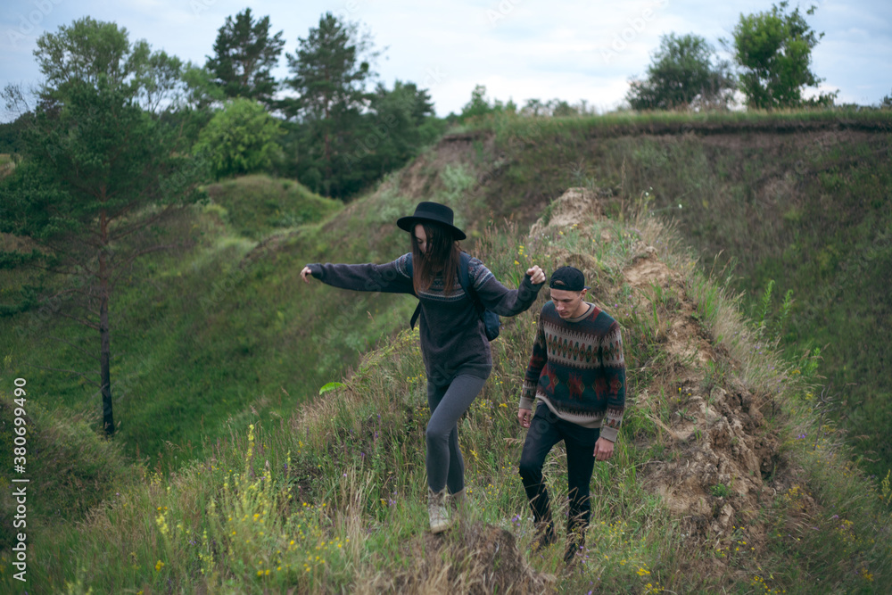 a guy and a girl walking on green hills a guy and a girl walking on green hills