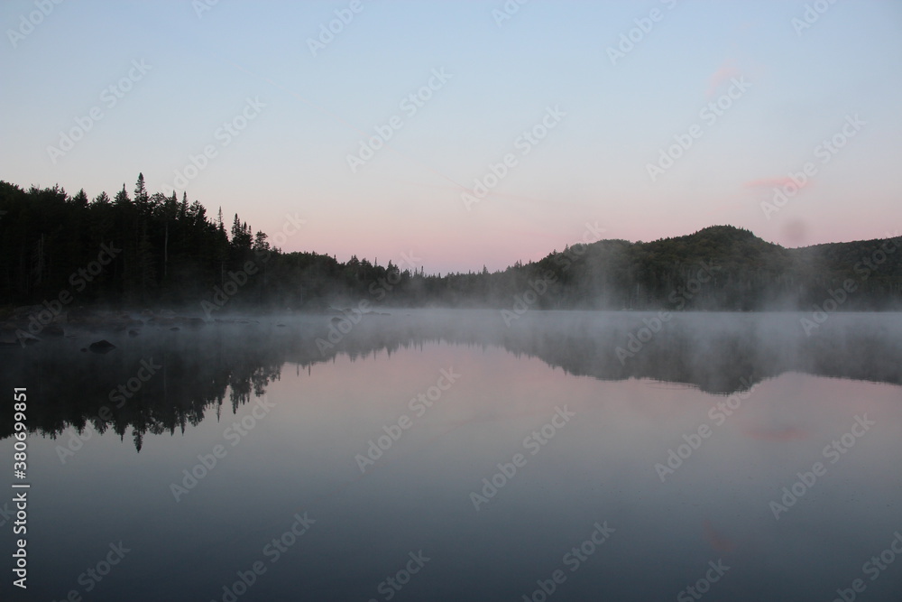 Fototapeta premium Mist rising from the warm lake at dawn