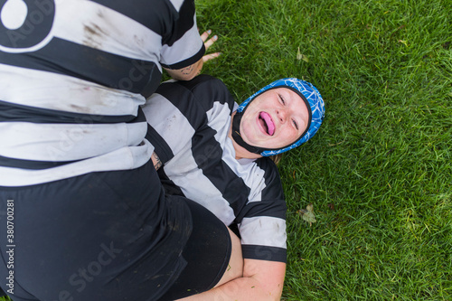 A female rugby player getting tackled by her teammate for fun.