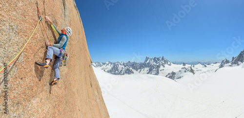 Man rock climbing on steep granite face photo