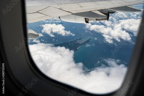 Фототапет View through an airplane window over tropical island