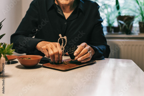 Anonymous Senior Citizen Putting CBD Cannabis in Grinder