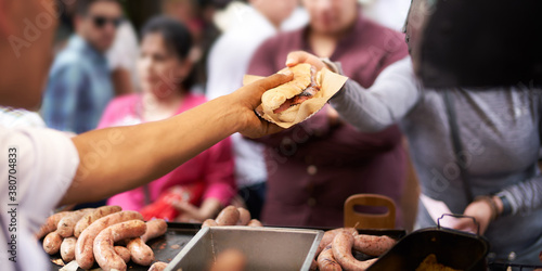 Cook selling sandwich to customer at street food stall photo