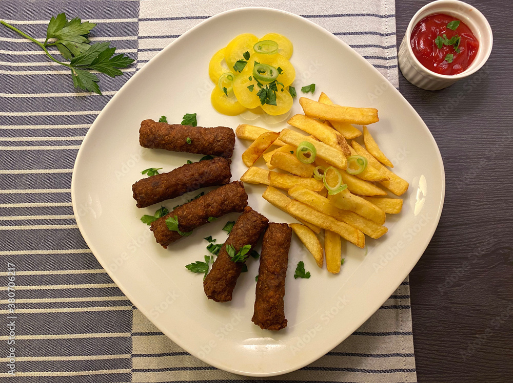 Cevapcici with french fries and ketchup. Grilled minced meat dish, a type of kebab.