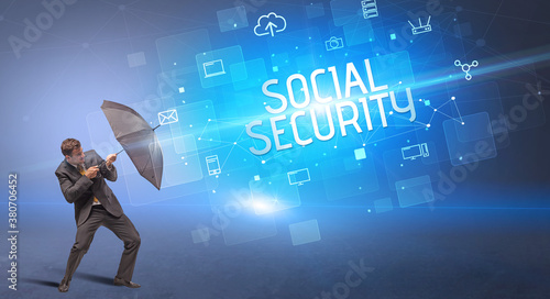 Businessman defending with umbrella from cyber attack and SOCIAL SECURITY inscription  online security concept