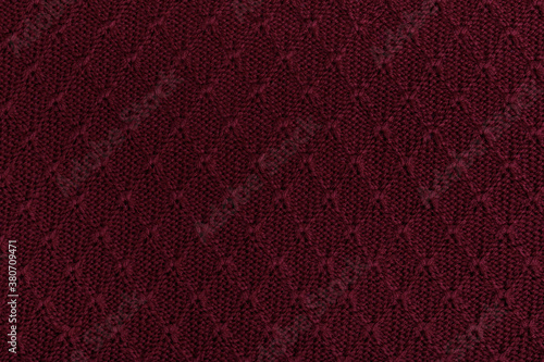 Burgundy knitted sweater. Rhombus pattern. Pattern close up.