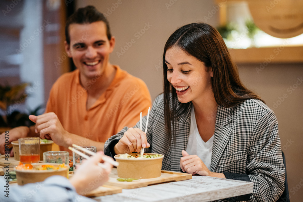 Couple eating poke bowl with chopsticks Couple eating poke bowl with chopsticks