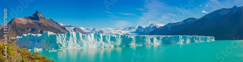 Panoramic view over gigantic Perito Moreno glacier in Patagonia with blue sky and turquoise water glacial lagoon, South America, Argentina, at sunny day..