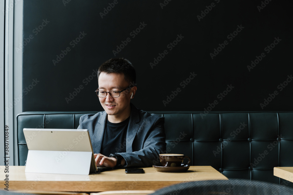 Businessman using laptop in cafeteria Businessman using laptop in cafeteria