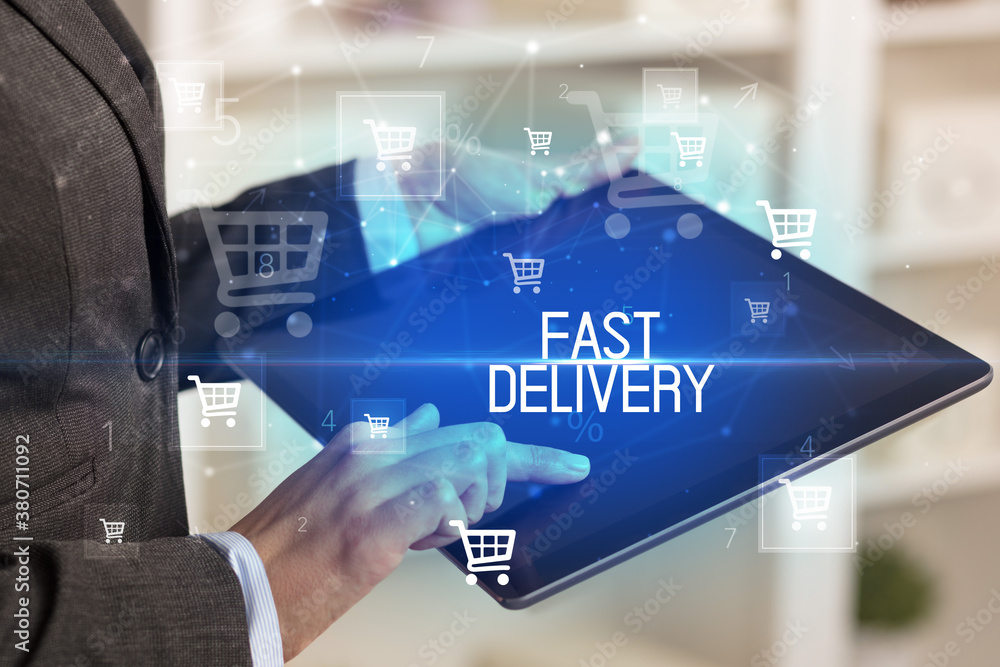 Young person makes a purchase through online shopping application with FAST DELIVERY inscription Young person makes a purchase through online shopping application with FAST DELIVERY inscription