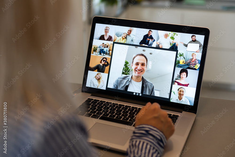 Back view of business woman talking to her colleagues about plan in video conference. Multiethnic business team using laptop for a online meeting in video call. Group of people smart working from home Back view of business woman talking to her colleagues about plan in video conference. Multiethnic business team using laptop for a online meeting in video call. Group of people smart working from home